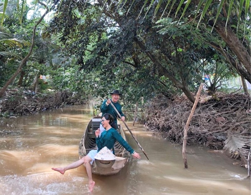 Hai bạn chèo thuyền, hát ca trên kênh.