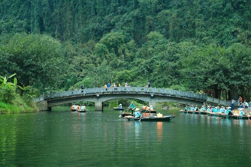 Dòng sông xanh biếc in bóng cây cổ thụ, tạo nên khung cảnh thơ mộng, như đưa du khách lạc vào thế giới cổ tích tại Tràng An.