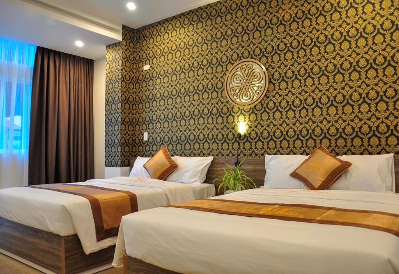 Phòng nghỉ Nice Hue Hotel sang trọng với gam màu vàng ấm áp, điểm xuyết gỗ nâu.