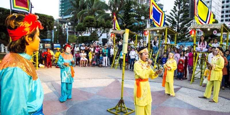 Hội Bài Chòi Nha Trang rực rỡ sắc màu từ trang phục, cờ, tạo nên khung cảnh vui tươi.