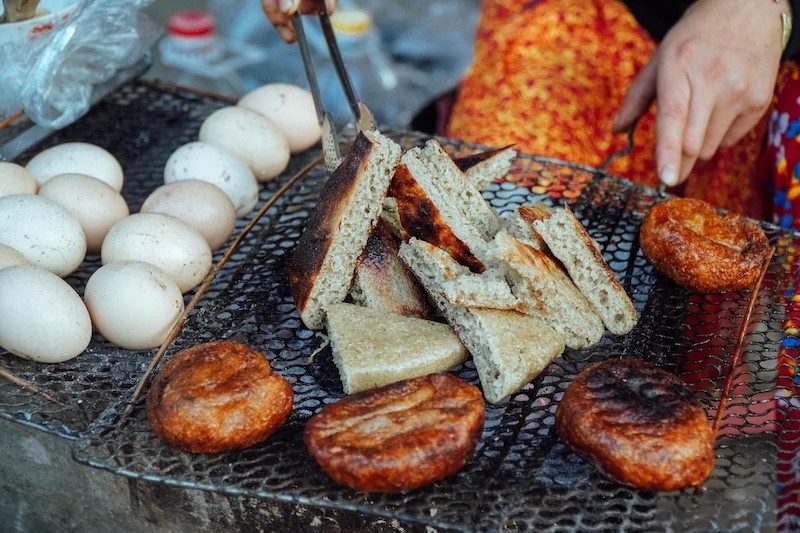 Bánh được nặn tròn dẹt, nướng trên than hồng, tạo vỏ giòn rụm, bên trong mềm xốp, ngọt dịu.