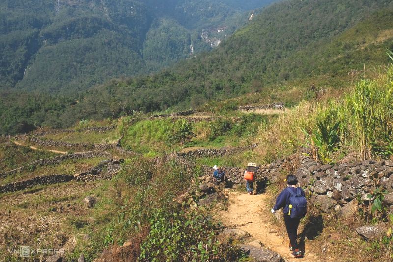 Lối mòn lên núi từ bản Nhìu Cồ San uốn lượn giữa ruộng bậc thang và hàng rào đá. (Ảnh: VnExpress)