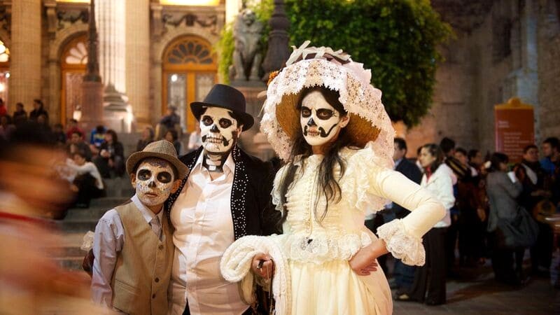 Lễ hội Người Chết rực rỡ sắc màu với những người dân hóa trang thành La Calavera Catrina, diện áo choàng và nón độc đáo.