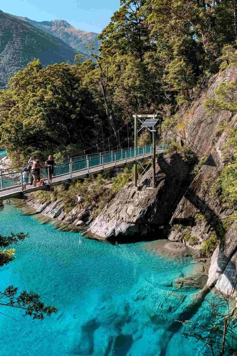 Cầu gỗ bắc ngang sông xanh biếc ở Mount Aspiring thu hút du khách.