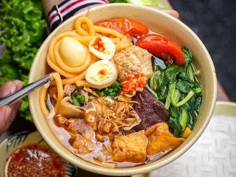 Tô bún riêu dì Sáu đầy ắp topping. (Ảnh: Kênh 14)