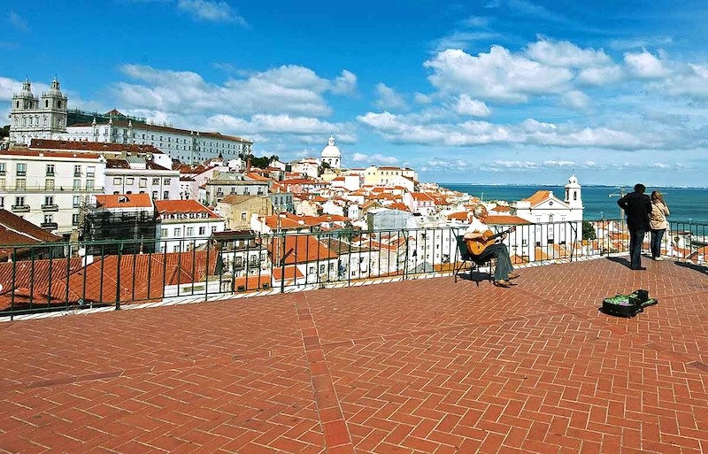 Alfama, thành phố cổ kính của Lisbon, mê hoặc với những con đường lát đá cuội và mái nhà nghiêng ngả trên sườn dốc.