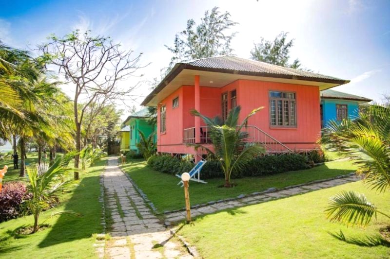 Bungalow TTC Resort Dốc Lết nằm giữa vườn cỏ xanh mát.