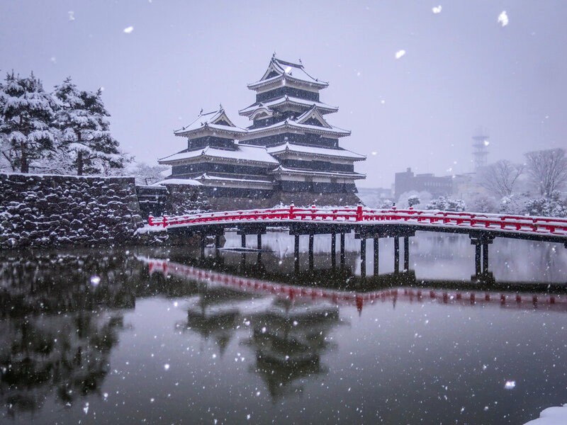 Lâu đài Matsumoto trắng phủ tuyết, cầu đỏ nổi bật. (Ảnh: 絶景事典)