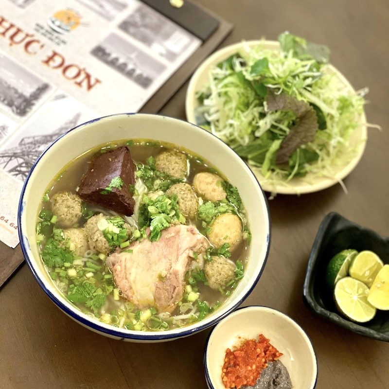 Bún riêu đầy đủ topping: huyết, đậu hũ, riêu cua, giò heo/sườn, mọc. (Ảnh: Bún riêu Blao Fanpage)