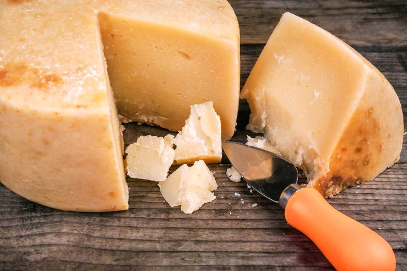 Parmigiano-Reggiano đạt chuẩn có khắc chữ, bề mặt không nứt, kết cấu khô, cứng và màu vàng đậm.